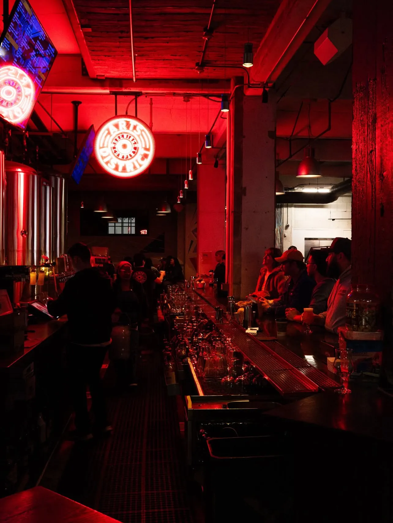 A packed bar under red light