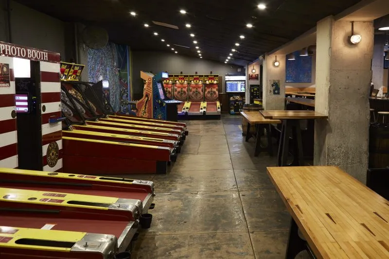 The floor with Skeeball lanes and long tables