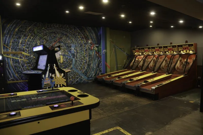Vintage Skeeball lanes lit up along the wall