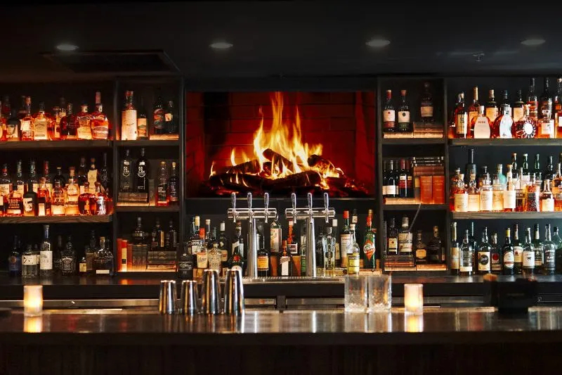 Bottles on the back bar, fire behind